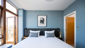 A bedroom with a large bed, two bedside tables, a headboard, a framed artwork, and a door. - Staycity Aparthotels, Dublin, Saint Augustine Street (Dublin)