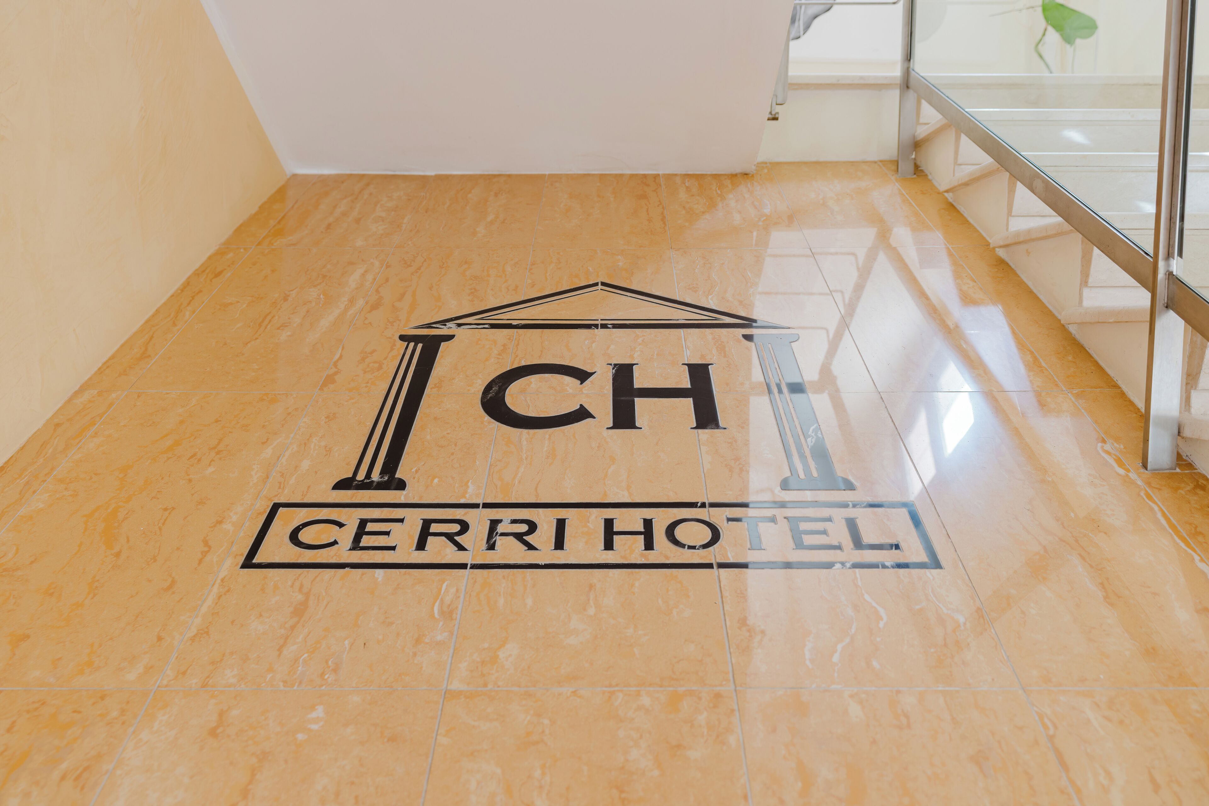 A hotel logo on a polished floor with a glass railing in the background.