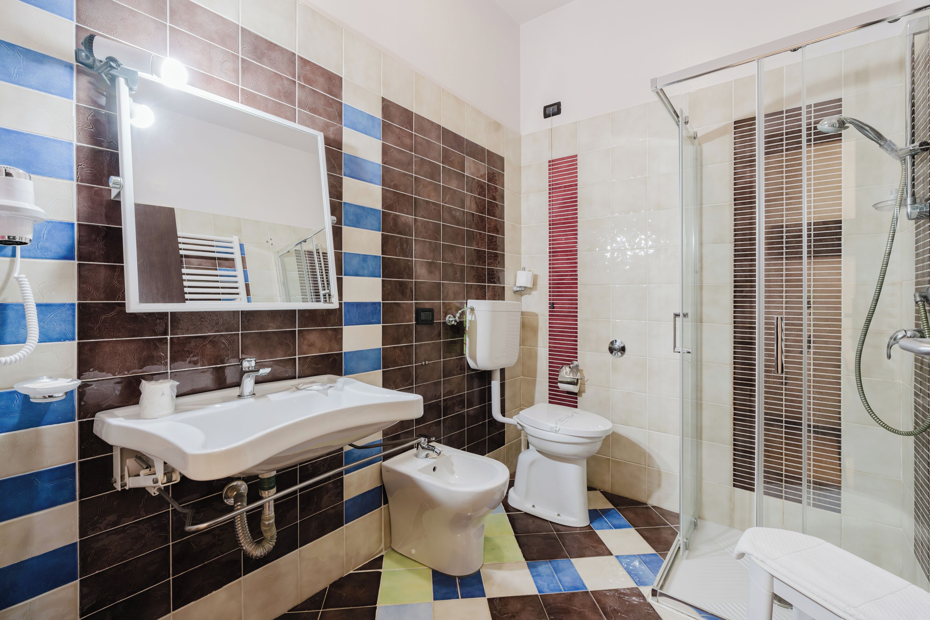 Ein Badezimmer mit Waschbecken, Toilette, Bidet und einer Duschkabine.