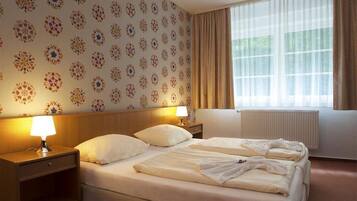 Ropa de cama hipoalergénica y caja de seguridad en la habitación