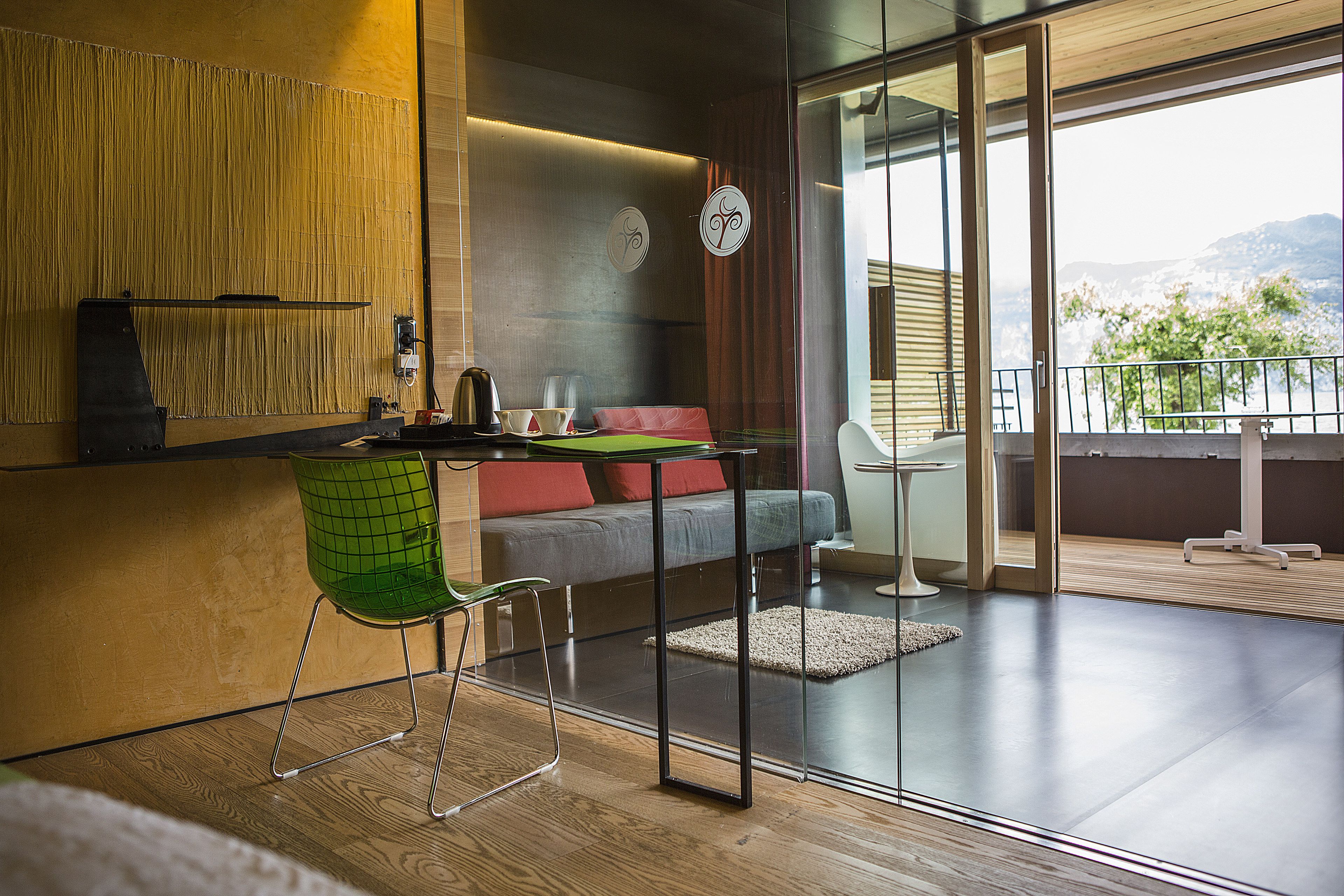 A modern living room with a sofa, a green chair, a coffee table, and a view of the outdoors.