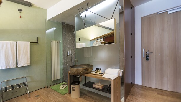 A modern bathroom with a glass shower enclosure, a wooden vanity, and a towel rack. - Ambienthotel Primaluna (Malcesine)