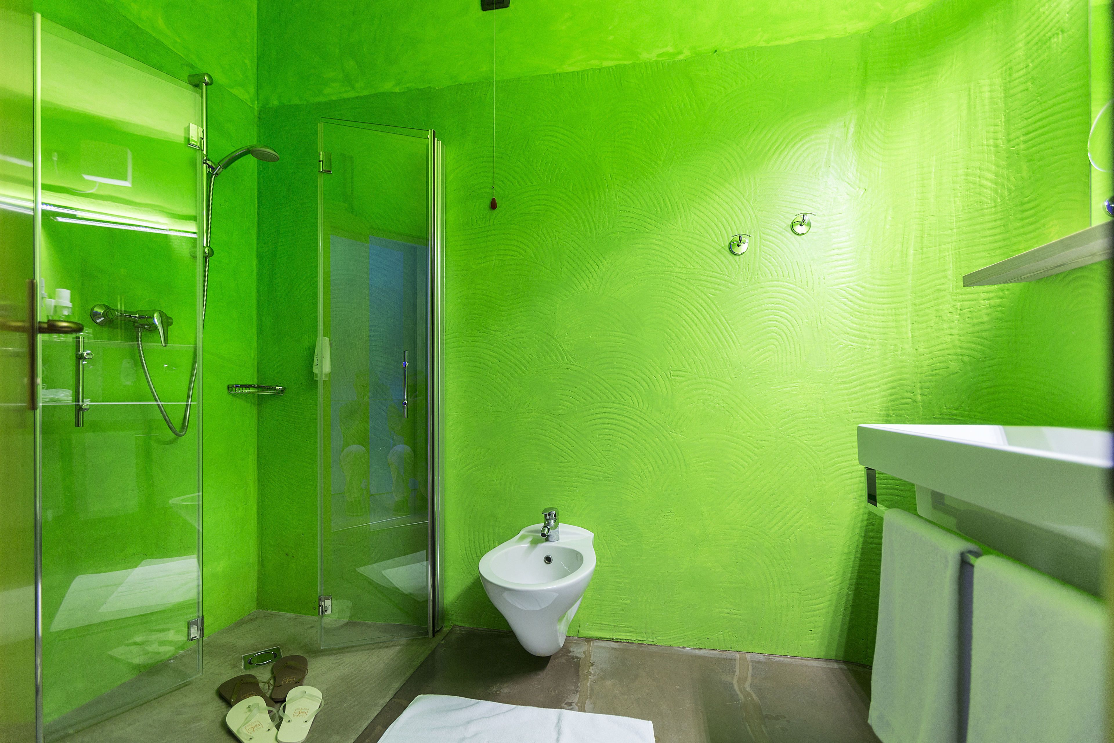 A bathroom with a glass shower enclosure, a bidet, and a white sink.