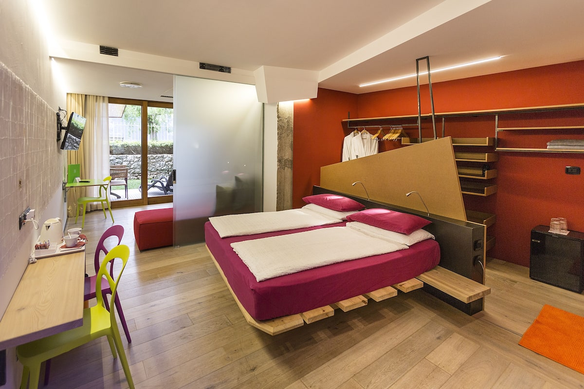 A modern bedroom with a bed, a desk, and a chair.