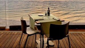A table set for two with a view of a lake and mountains in the background. - Ambienthotel Primaluna (Malcesine)