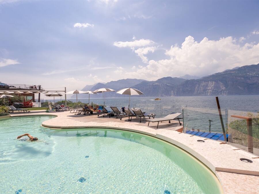 Piscina con vistas a montañas y un cuerpo de agua.