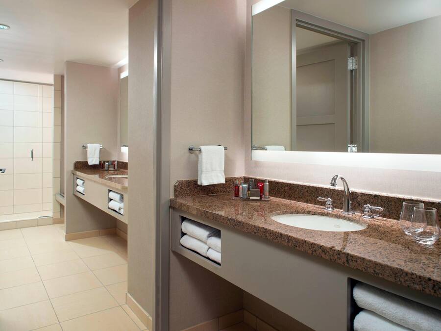 Een moderne badkamer met twee wastafels, een grote spiegel en een douchecabine.