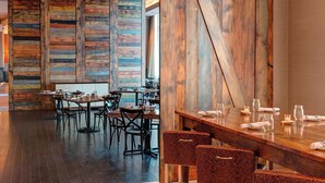 A restaurant with wooden walls and tables set for dining. - Raleigh Marriott City Center (Raleigh)