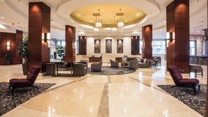 A spacious lobby with a central seating area, large pillars, and a modern ceiling design. - Raleigh Marriott City Center (Raleigh)
