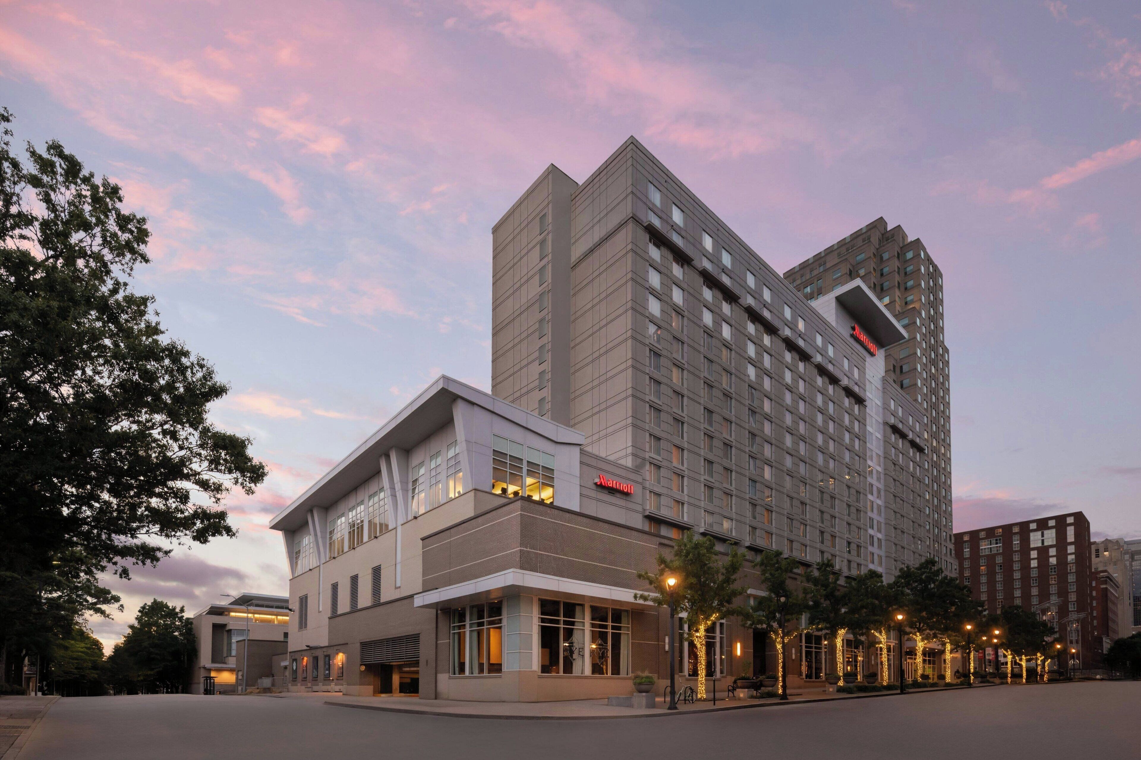 A Marriott hotel with a modern design, featuring a prominent corner entrance and a large building with multiple floors.