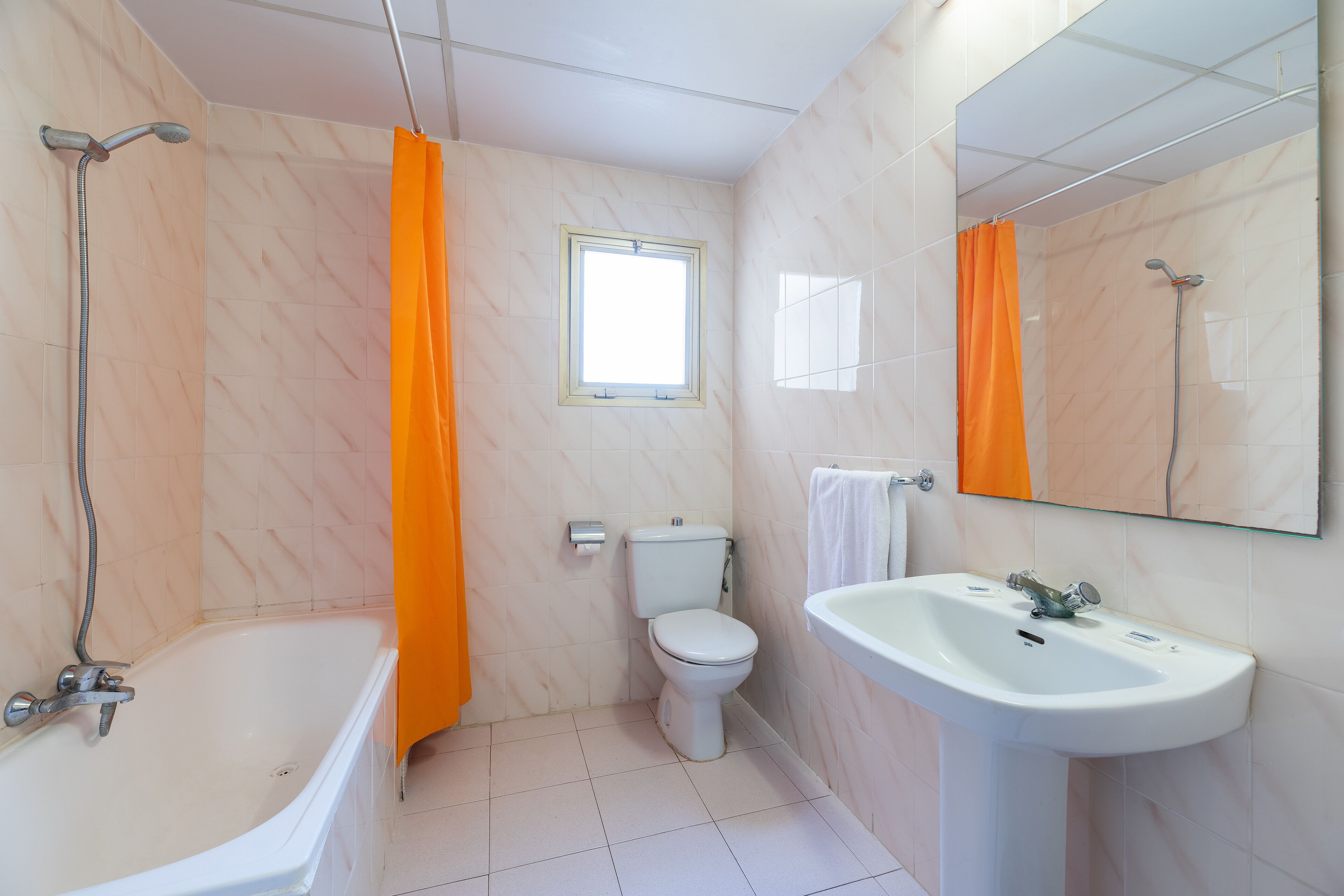 A bathroom with a bathtub, toilet, and sink.