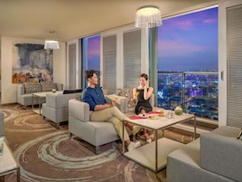 Un hotel moderno con vista a la ciudad, un cuadro grande en la pared y un comedor con mesa y sillas.