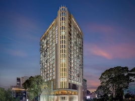 Un hotel de altura con diseño moderno, que cuenta con varios pisos y un llamativo letrero 