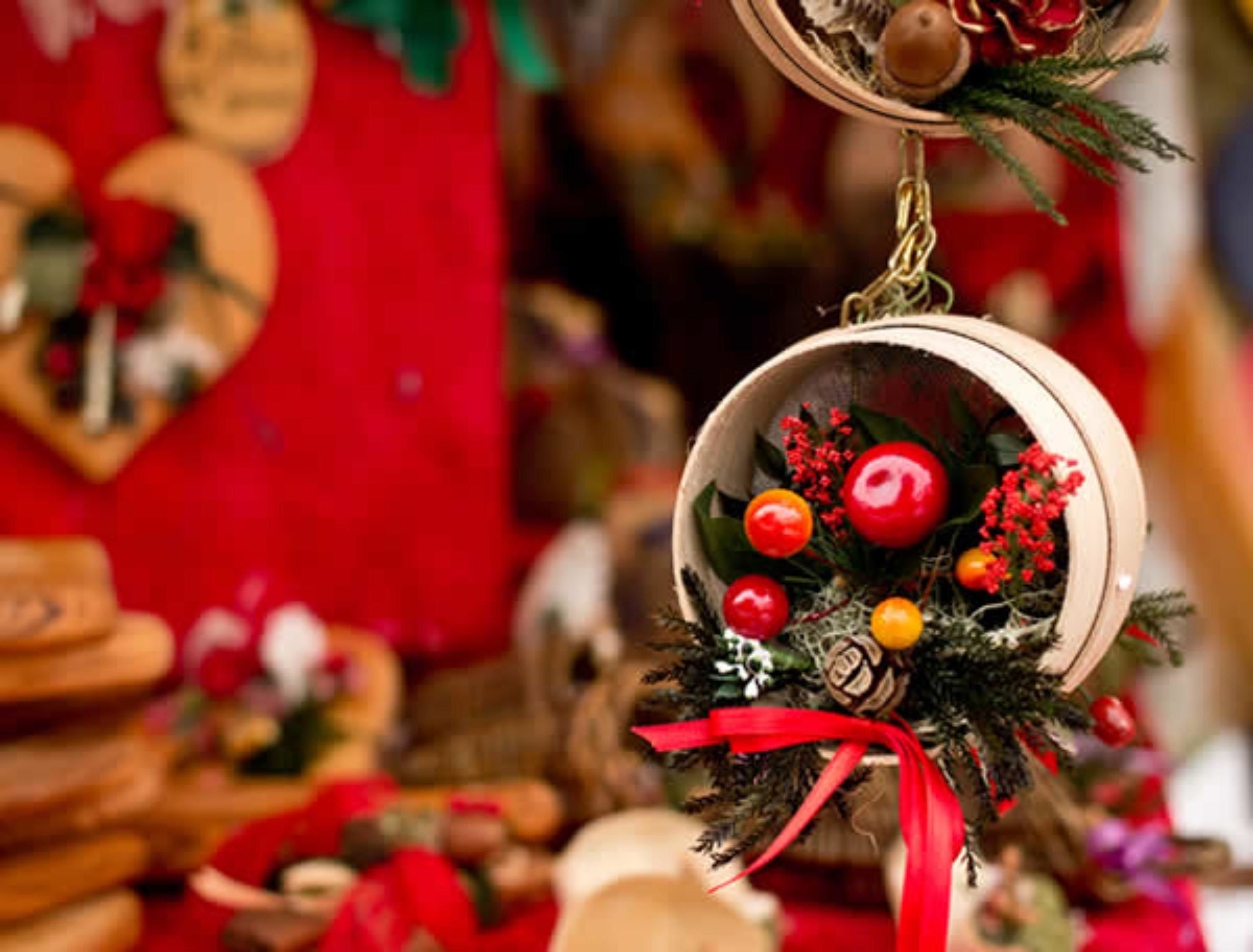 Ein Weihnachtsdekor mit rotem Band und Holzfuß.