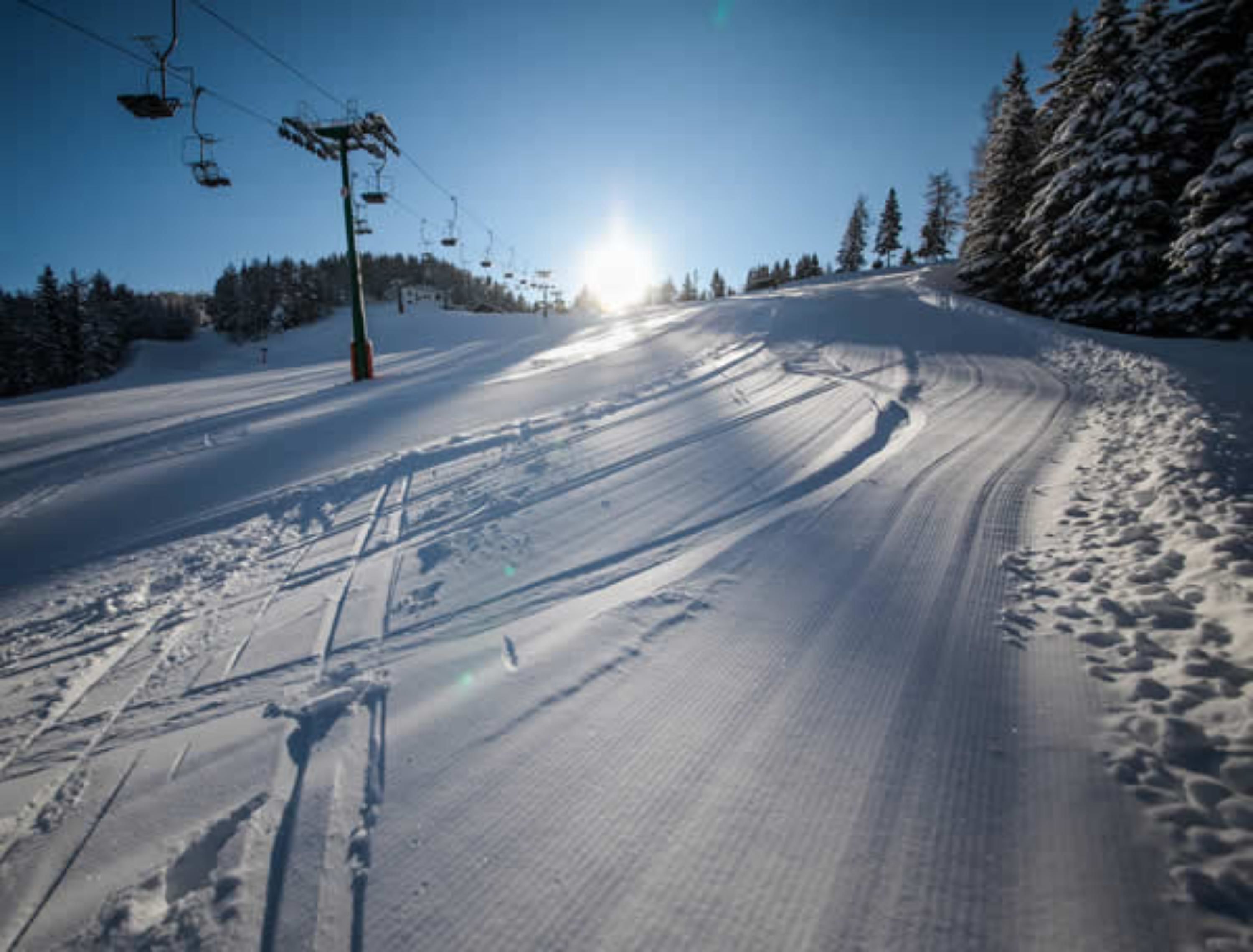 Eine Skipiste mit Skiliften und Bäumen.