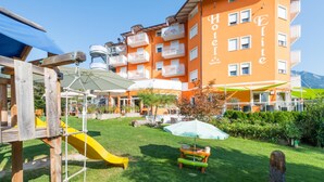 A hotel with a playground area, including a slide and swings, and a picnic table. - Nature Bio Hotel Elite (Levico Terme)
