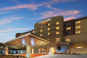 Un hotel Courtyard Marriott de diseño moderno, con entrada cubierta y varios pisos.