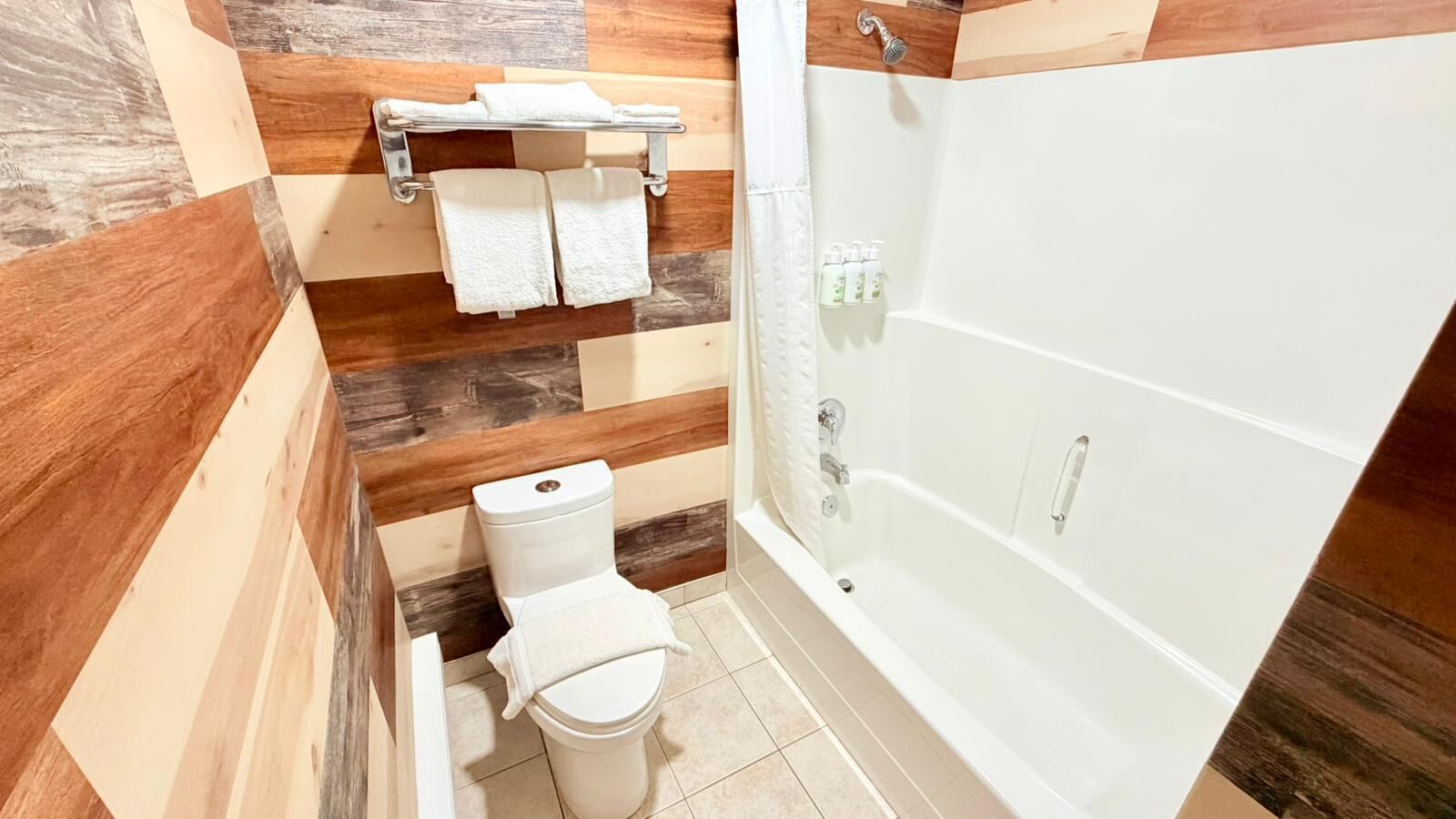 Une salle de bain équipée de toilettes, d’une douche et d’un porte-serviettes.