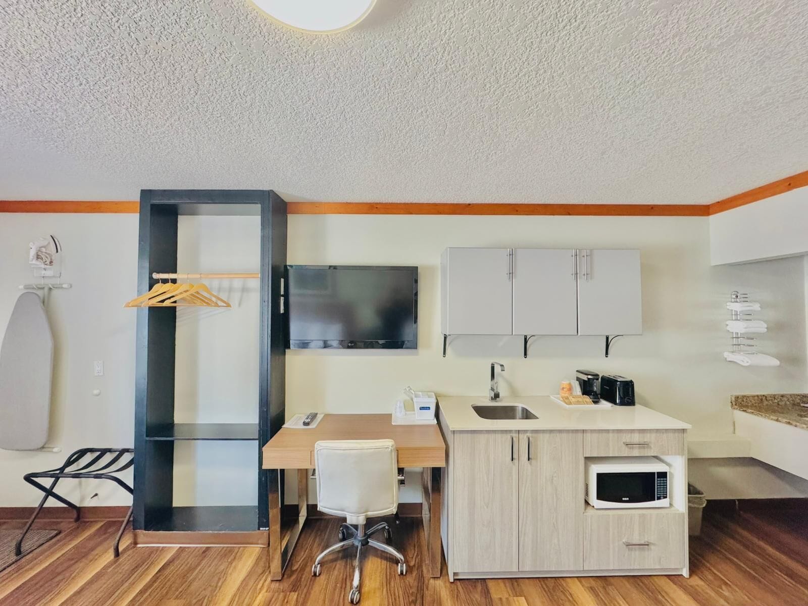 Una kitchenette compacta equipada con microondas, tostadora y pileta.