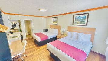 Une chambre d’hôtel avec deux lits, un bureau et une chaise.