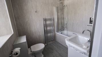 Ein modernes Badezimmer mit Toilette, Dusche und Waschbecken.