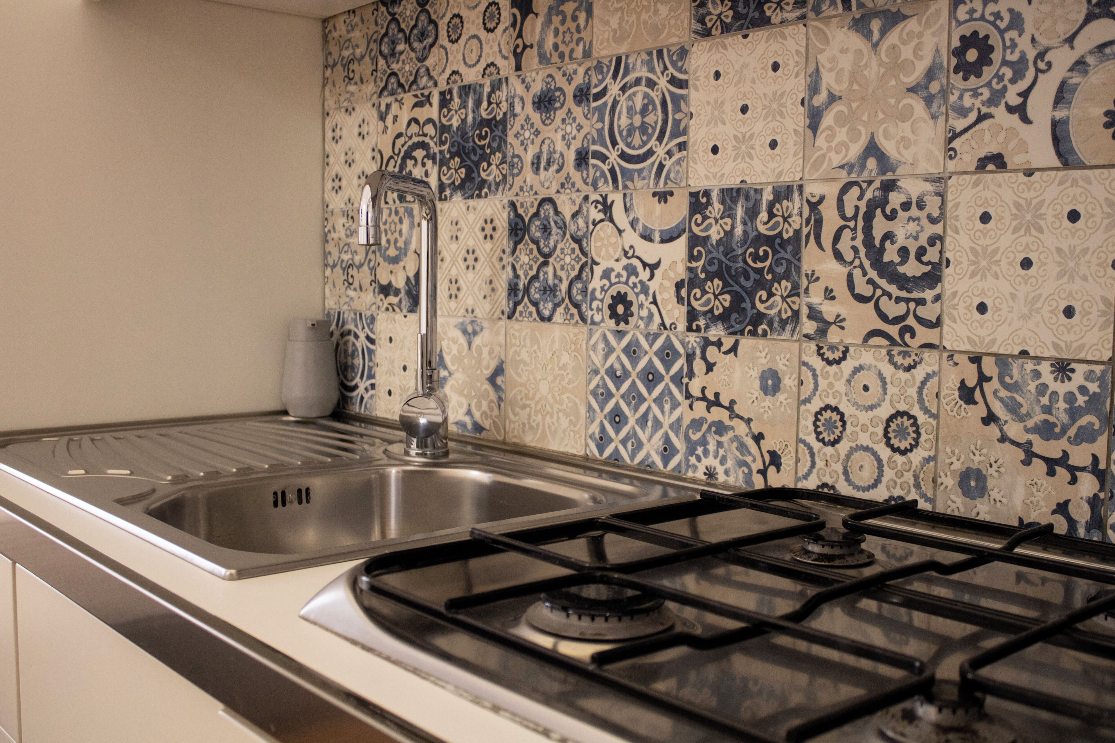 A kitchen with a stainless steel sink and a gas stove.