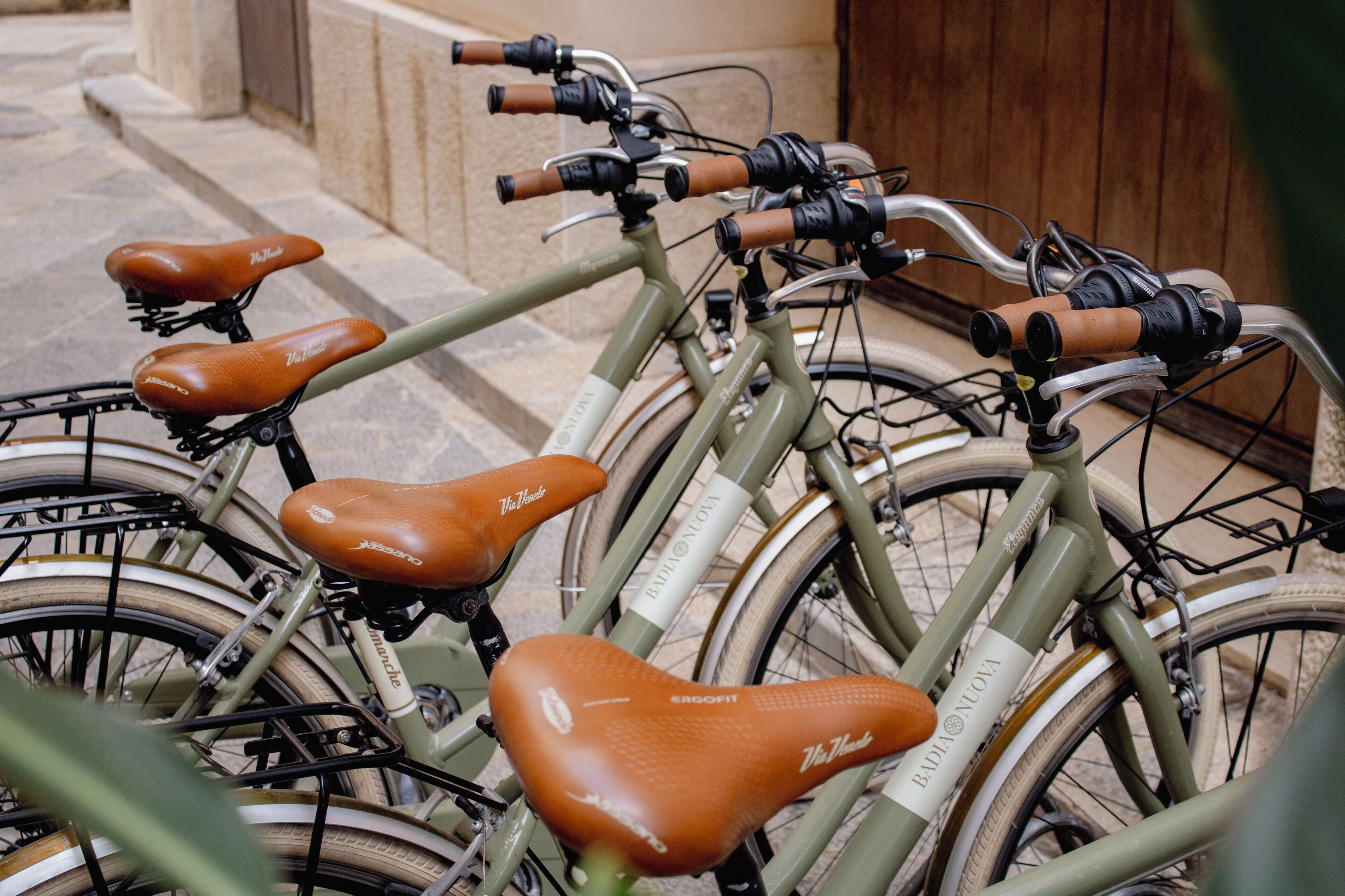 A row of bicycles with brown leather seats and a white label on the frame.
