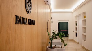 A reception area with a wooden wall, a logo, and a sign that reads "BADIA NUNOA". - BADIA NUOVA Apart Hotel (Trapani)