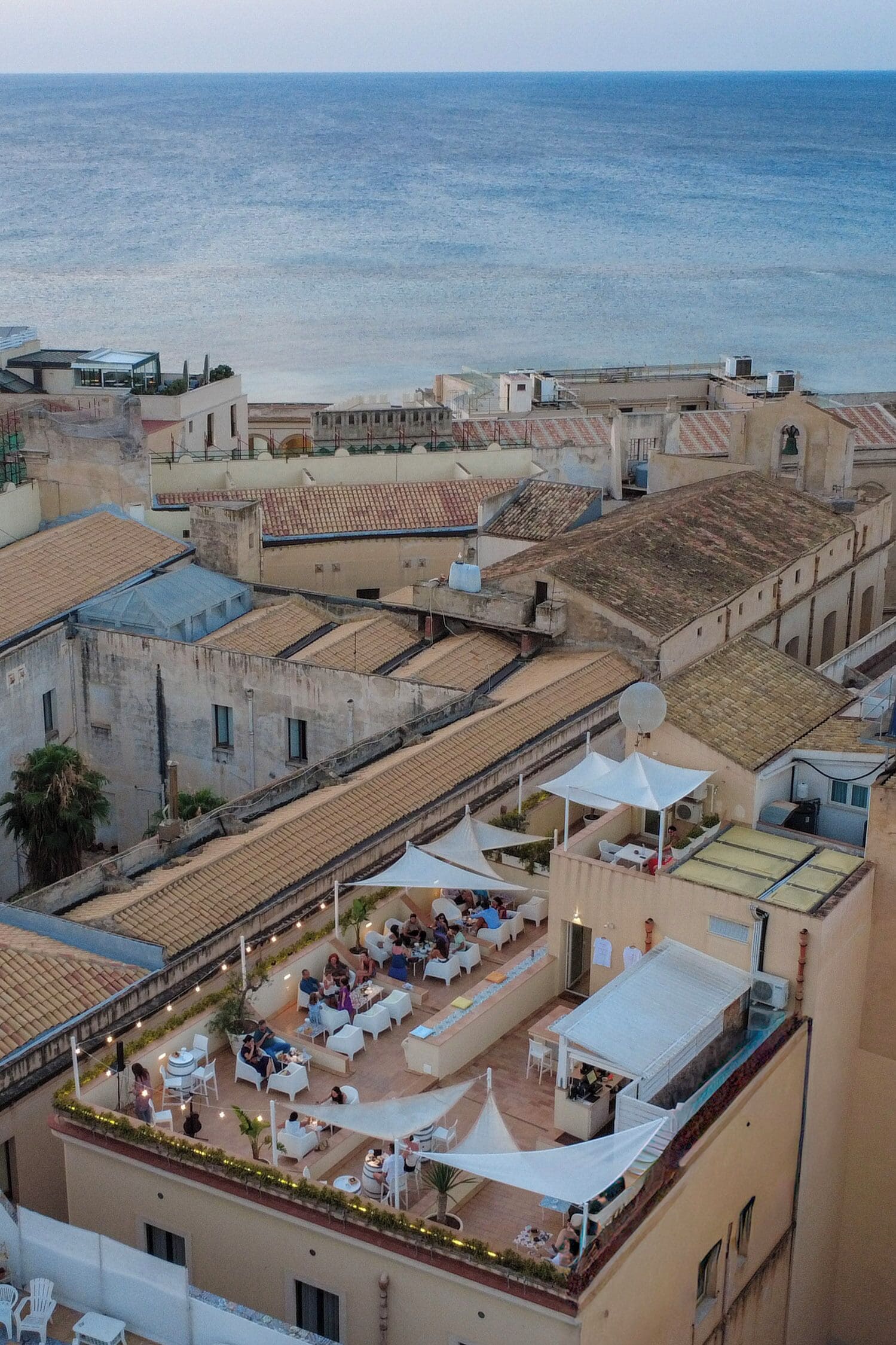 Una terrazza sul tetto con posti a sedere all'aperto e vista sul mare.