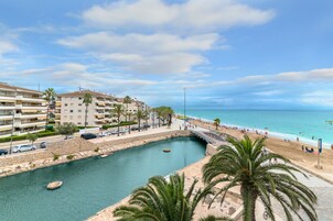 Zona costera con un puerto deportivo, playa y edificios residenciales.