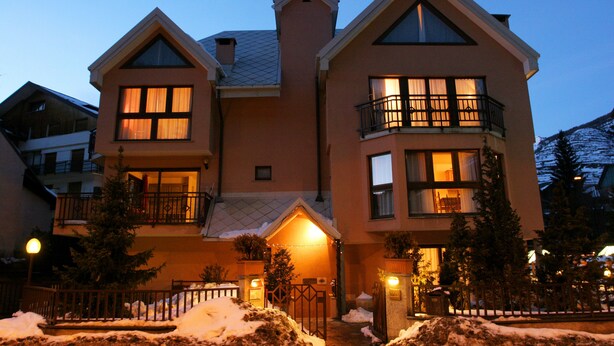 A multi-story building with a symmetrical facade, large windows, and balconies. - Residence villa Frejus (Bardonecchia)