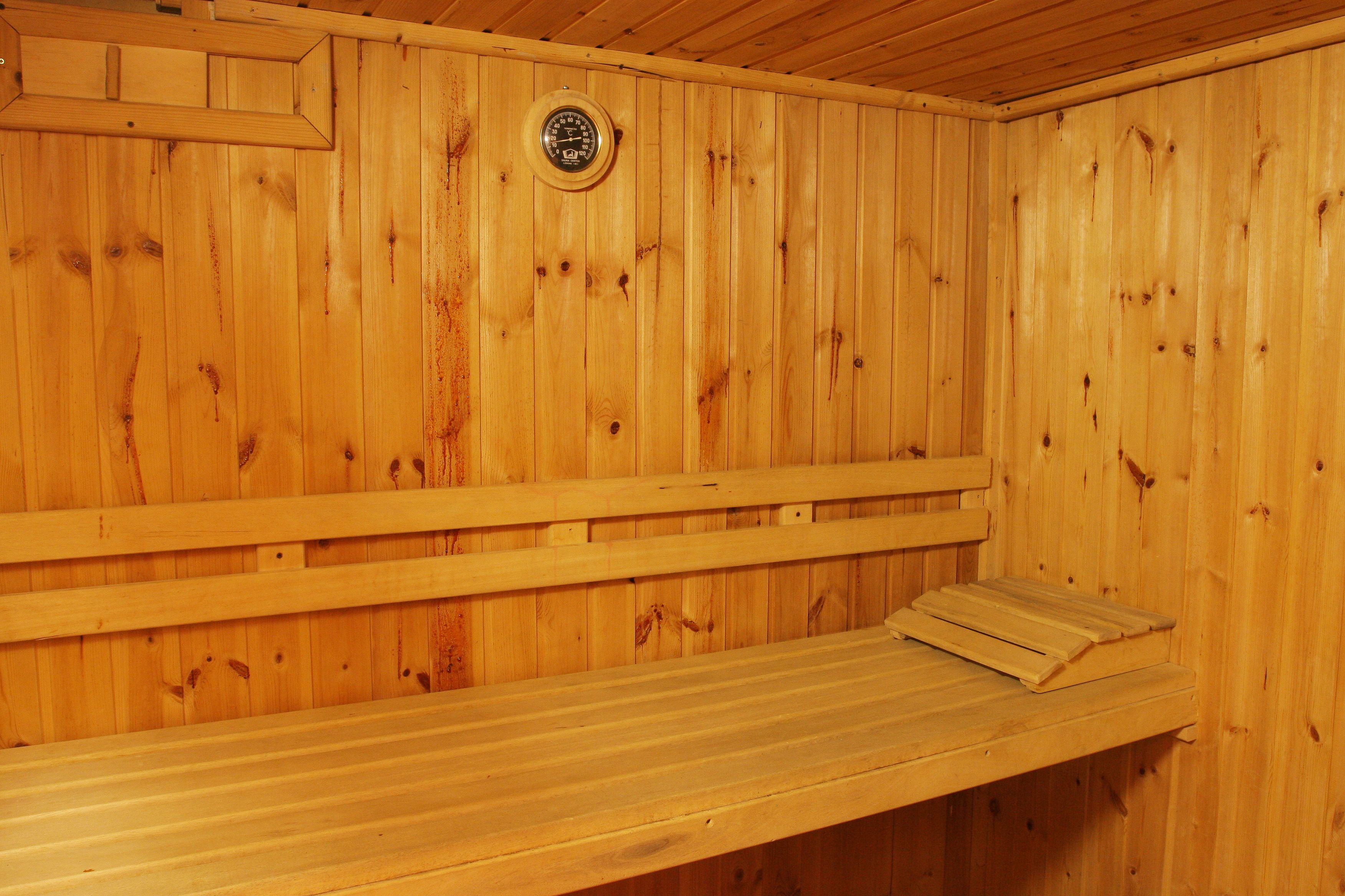 A wooden sauna with benches and a visible water level gauge.