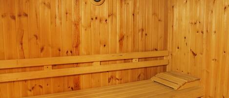 A wooden sauna with benches and a visible water level gauge.