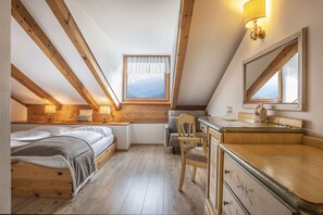 Une chambre avec un plafond en bois, un lit, un bureau et une chaise.