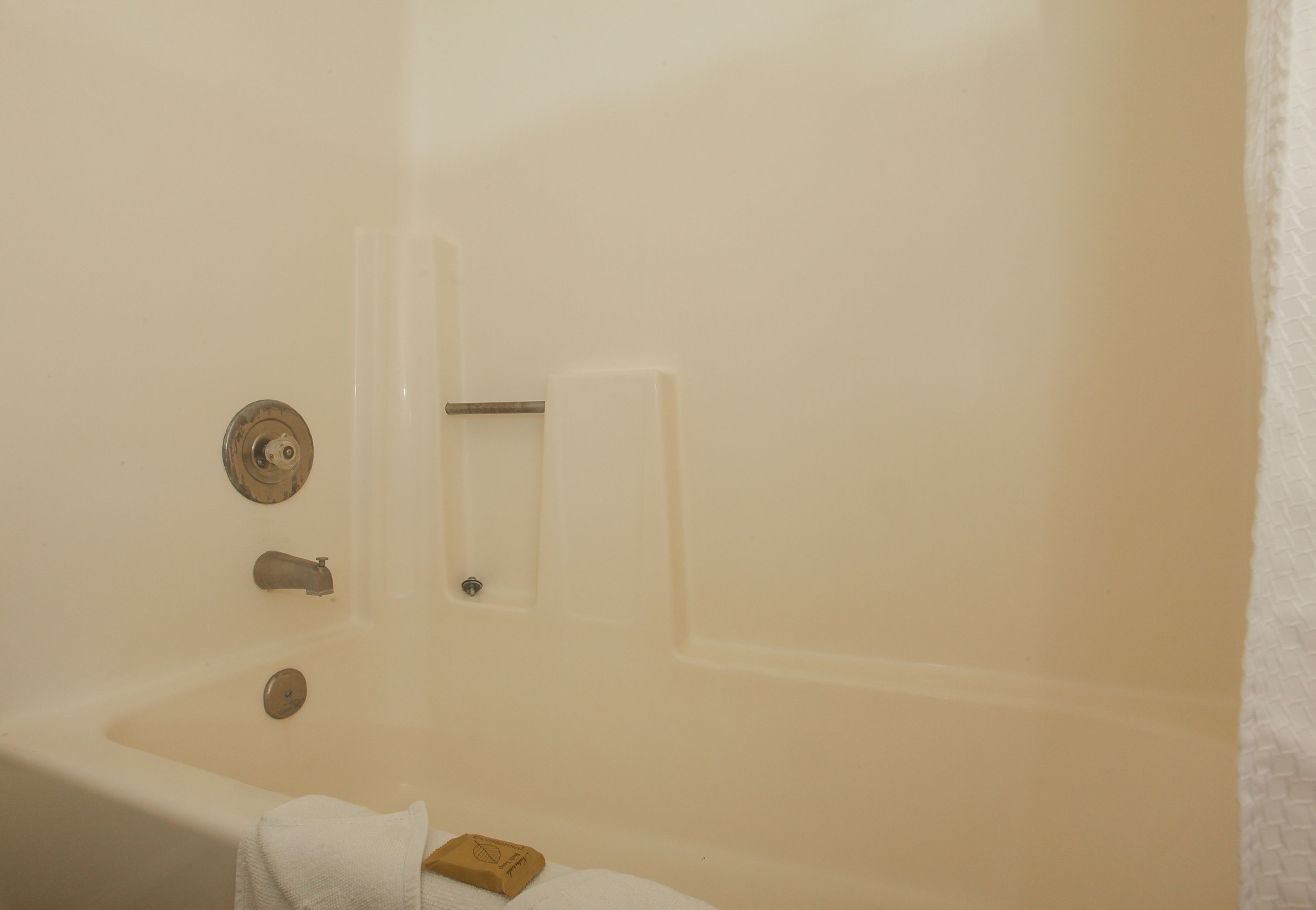 Ein Badezimmer mit einer Badewanne, einem Handtuch und einer Seifenschale.