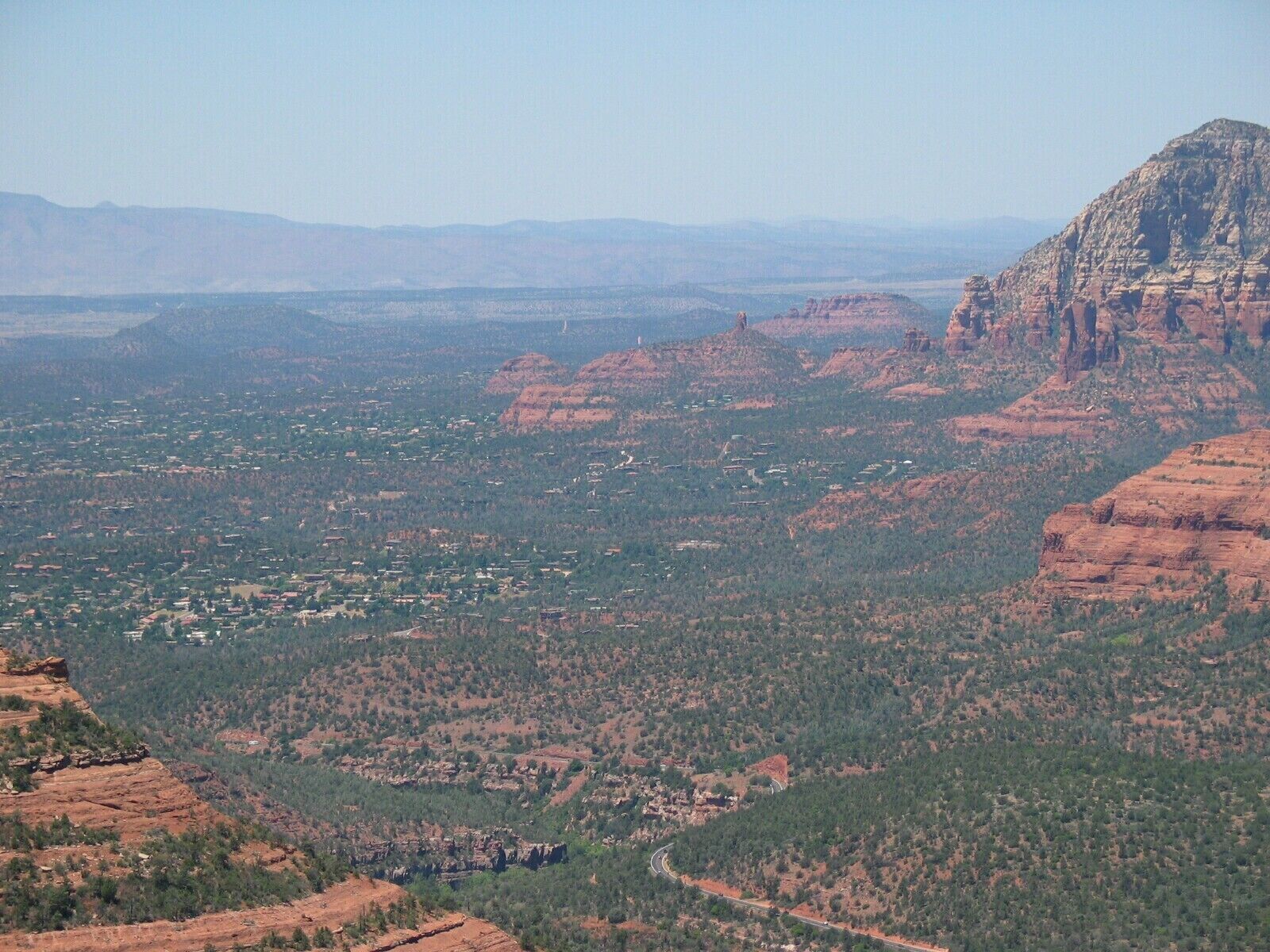 Une vue panoramique d’un paysage montagneux, avec une ville nichée au creux des collines.