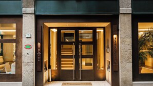 A hotel entrance with a double door, a reception desk, and a sign indicating the hotel name.