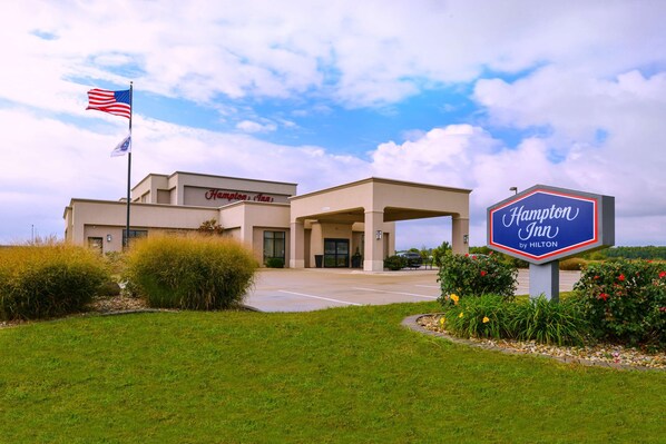 A Hampton Inn by Hilton building with a parking lot and a flagpole with the American flag. - Hampton Inn by Hilton Lincoln (Lincoln)