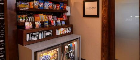 A snack bar with shelves of snacks and a refrigerated display.