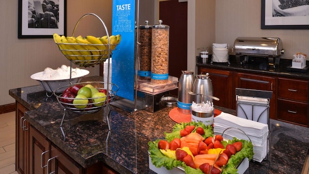 Montaje de bufé con frutas, ensalada y estación de bebidas.