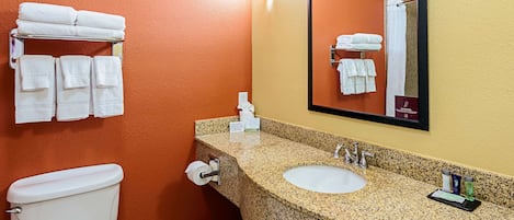 A bathroom with a toilet, sink, and towel rack.