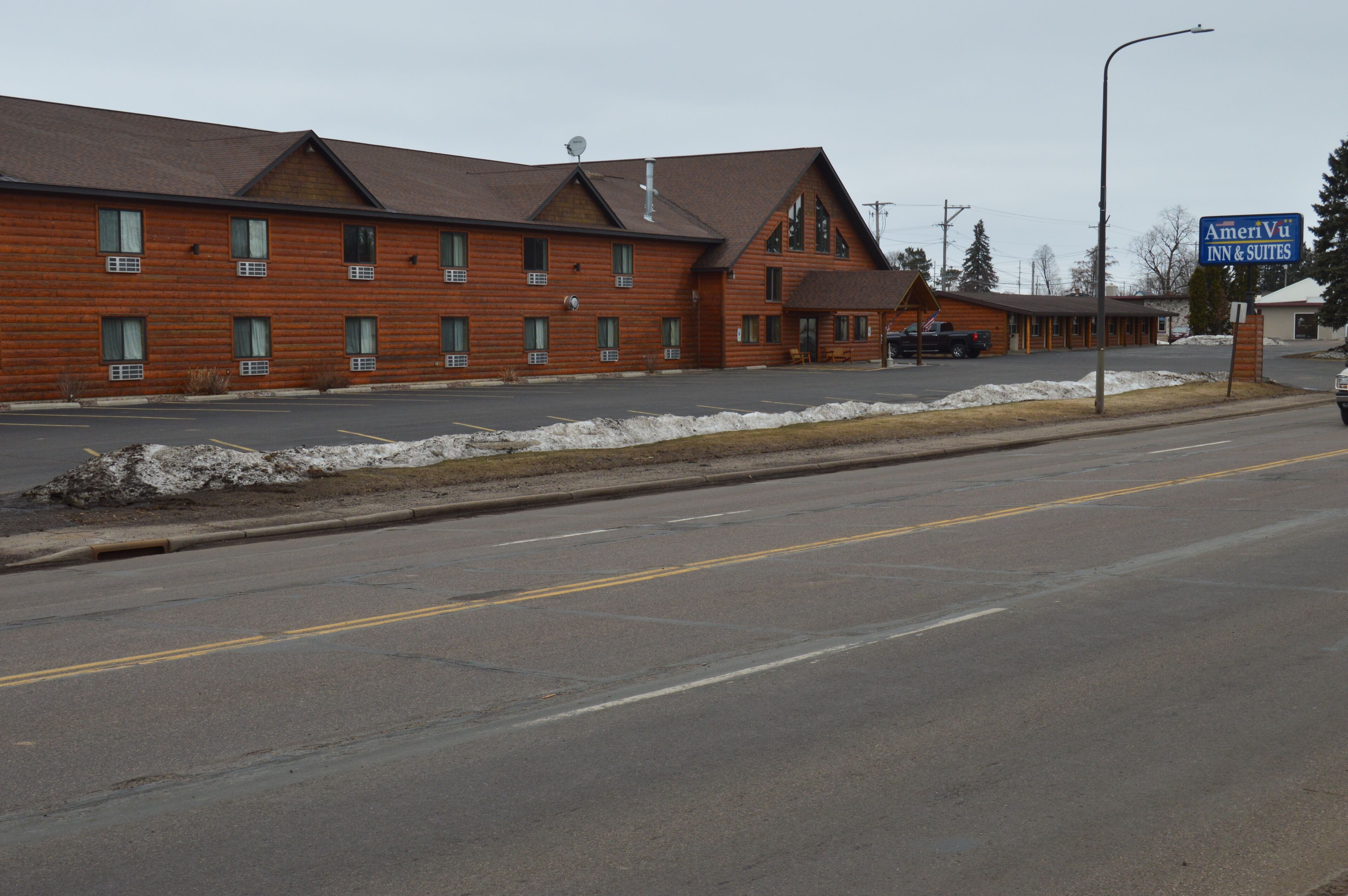 A two-story log cabin-style building with a sign for AmeriVui Inn & Suites.