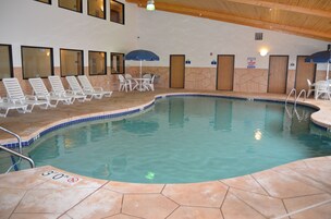 Una piscina techada, sillones reclinables de piscina