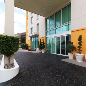 A modern building with large windows and a paved courtyard. - Hampton Inn by Hilton Reynosa/Zona Industrial (Reynosa)