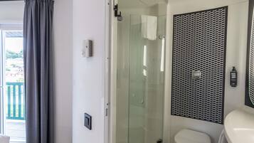Une salle de bain moderne avec une douche à parois de verre, des toilettes et un lavabo avec un miroir.