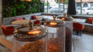 A modern interior with a seating area, large windows, and decorative glass containers with a spherical top. - ibis Ciboure St Jean De Luz Hotel (Ciboure)