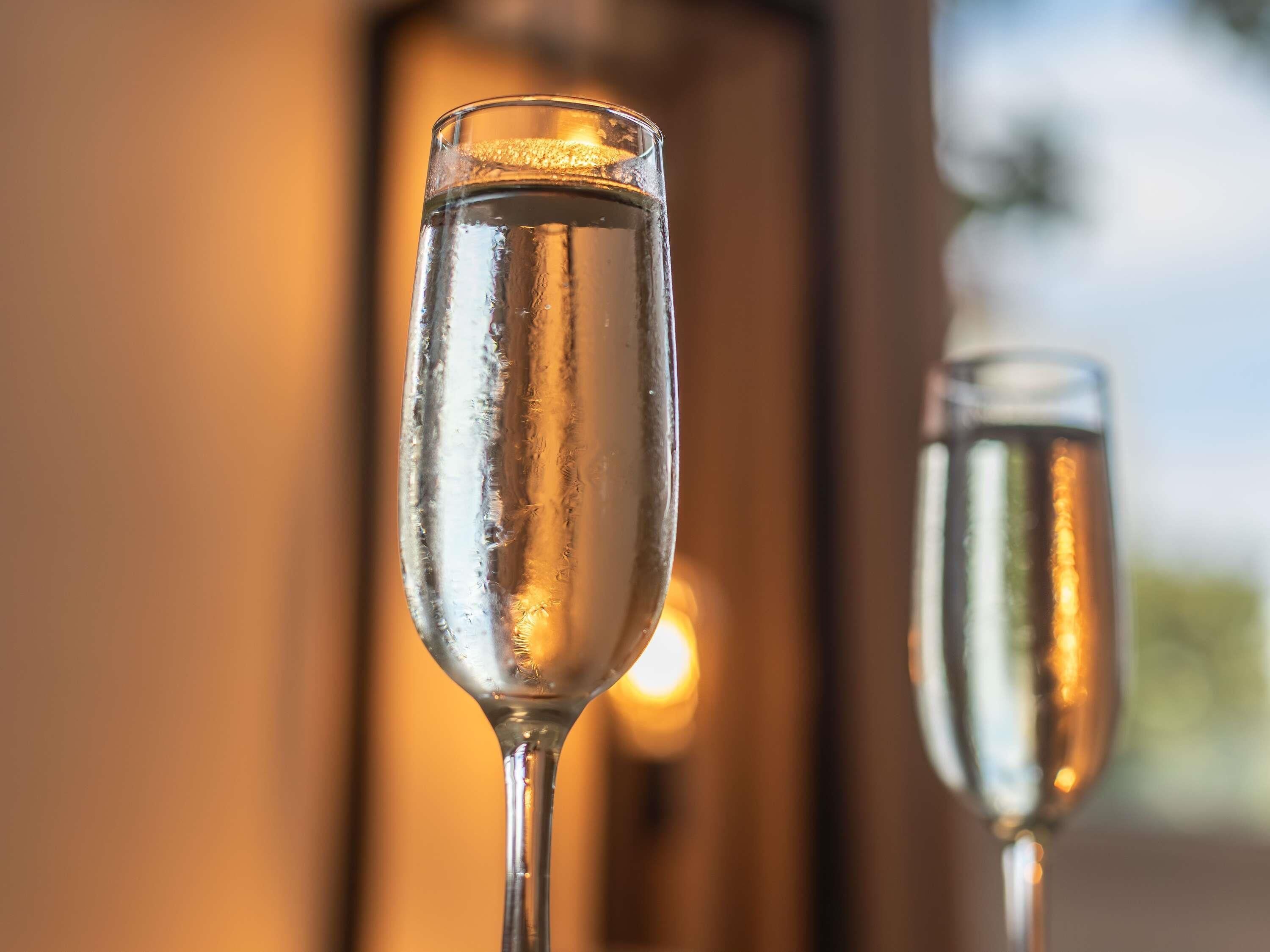 Two champagne flutes with a blurred background.