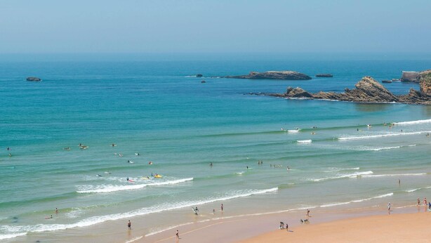 A beach with clear water, rocky outcrops, and people engaging in water activities. - ibis Ciboure St Jean De Luz Hotel (Ciboure)