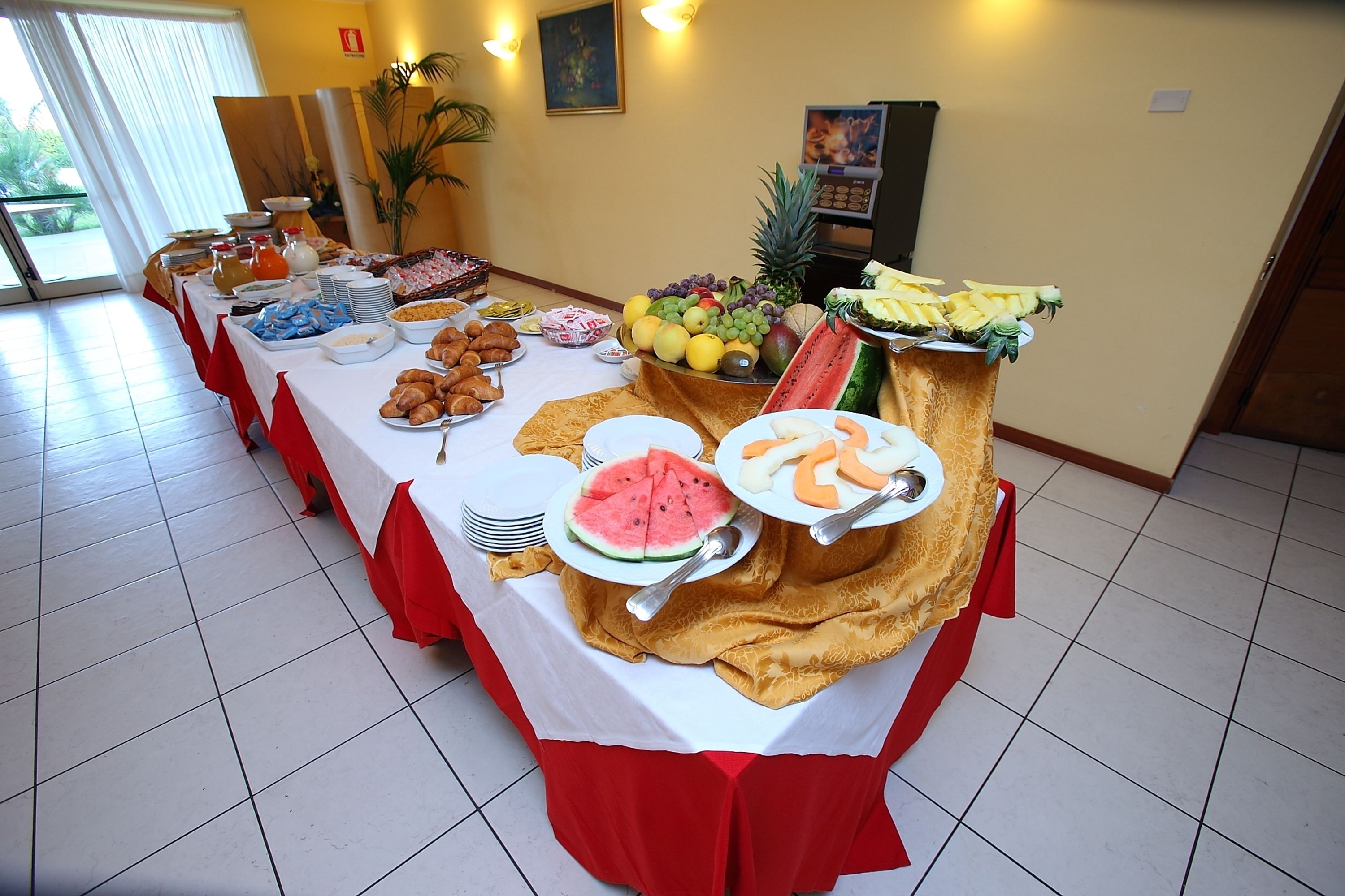 Ein Buffett mit verschiedenen Speisen und einer Wassermelone als Mittelpunkt.