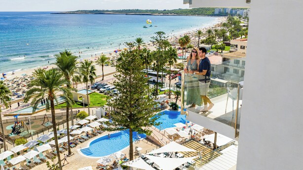 A resort with a pool, beach, and palm trees. - CM Playa del Moro Hotel (Sant Llorenc des Cardassar)